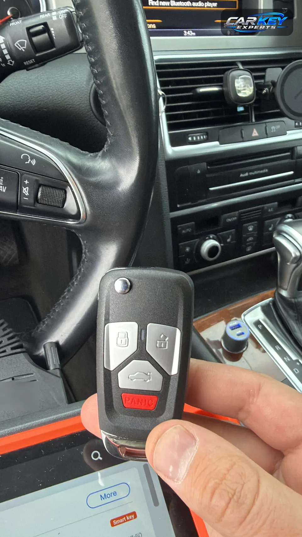 A new flip key with the remote in its head, inside an Audi, with the key programming tablet below