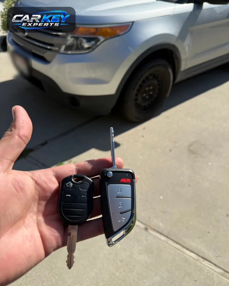 An old Ford remote-head key and the new flip key held in front of a silver Ford Explorer