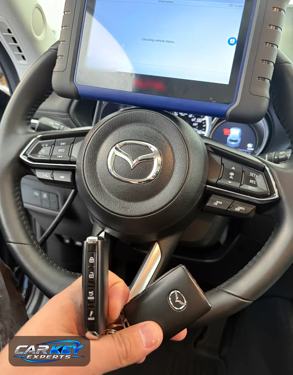 Programming tablet mounted on a Mazda steering wheel while a new smart key is paired to the car