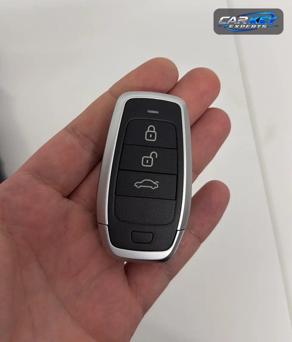 A three-button push-to-start smart key resting in an open hand