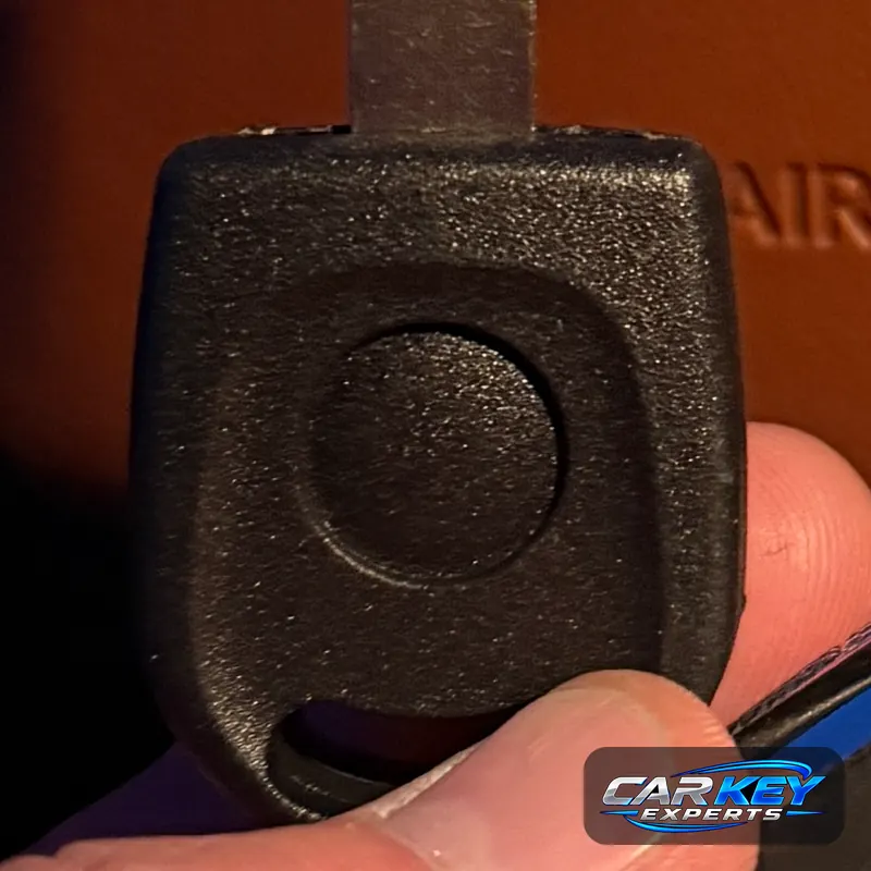 Plain black plastic head of a new chip key, where the transponder sits